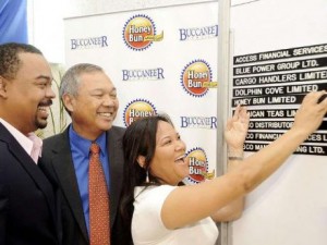 Michelle Chong (right), chief executive officer of Honey Bun Limited, inserts Honey Bun on the JSE Junior Stock Exchange listing board on Friday, June 3, and is watched by (from left) Gary Peart, chief executive officer of Mayberry Investments Limited, which arranged the initial public offering, and Herbert Chong, chairman of Honey Bun Limited.